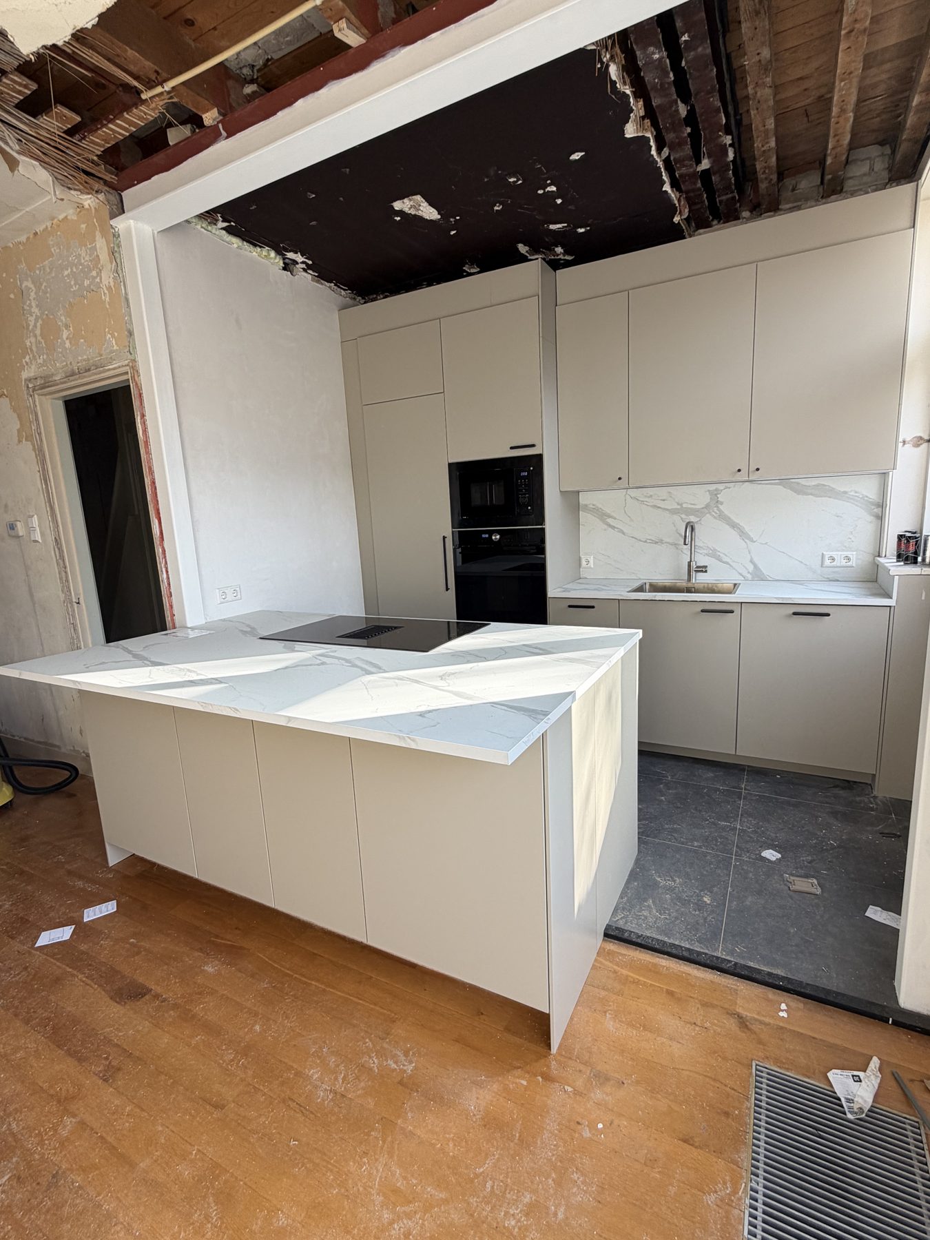 Beige keuken met marmerlook werkblad en kookeiland